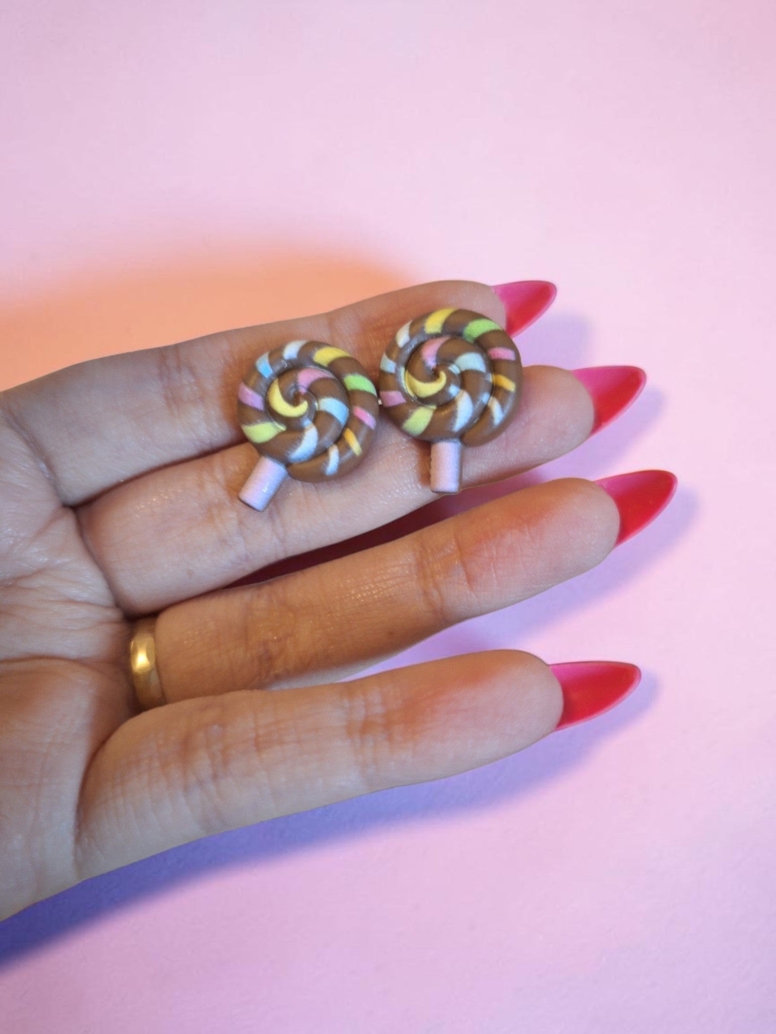 Carolinas Beautiful Jewerly örhängen formade som chokladbruna klubbor med färgglada ränder i gult, rosa och vitt.